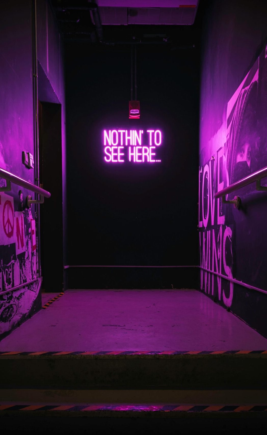 Dramatic neon-lit staircase with a unique illuminated sign creating an urban vibe.